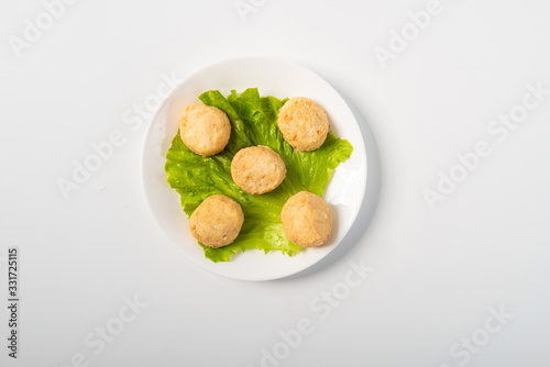 The steamed buns made of cheese and minced fish paste and fried with egg white are placed in the plate, isolated in the white background