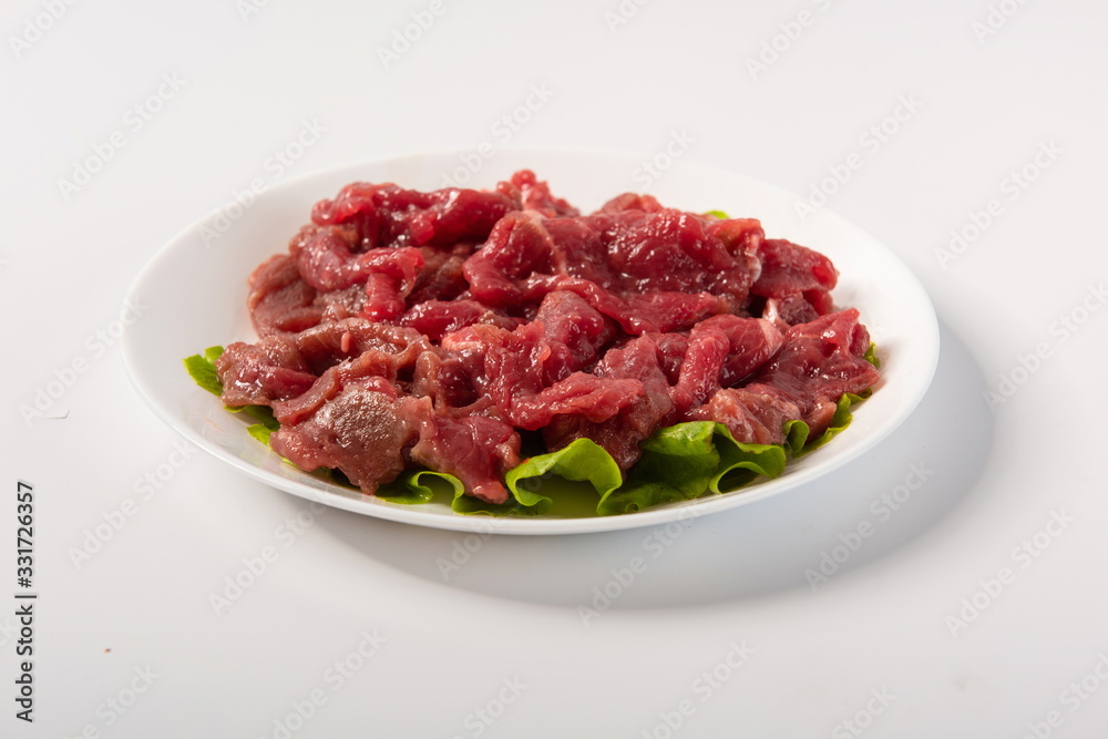 Australian beef slices are placed on plates, isolated in a white background Australian beef slices are placed on plates, isolated in a white background