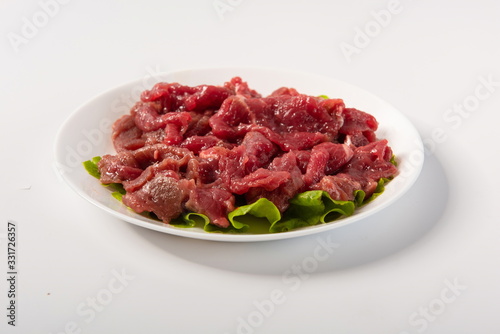 Australian beef slices are placed on plates, isolated in a white background