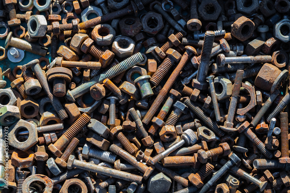 Many old rusty bolts and nuts of various sizes lie on the surface. Orange gray. Background or wallpaper. Many old rusty bolts and nuts of various sizes lie on the surface. Orange gray. Background or wallpaper.