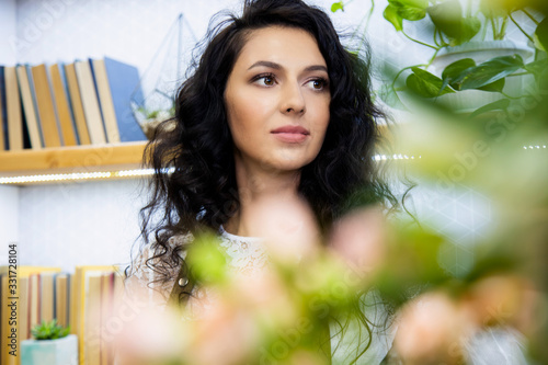 Portrait of an attractive young woman florist working in a flower shop.