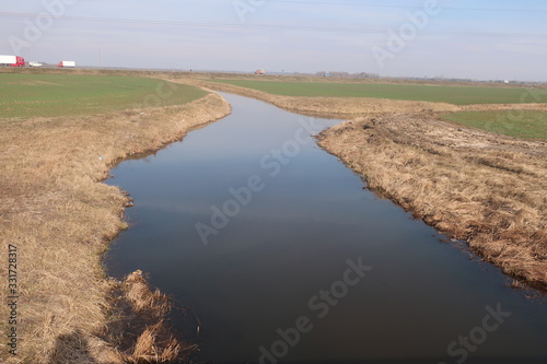  beautiful river on a background of blue sky and green field