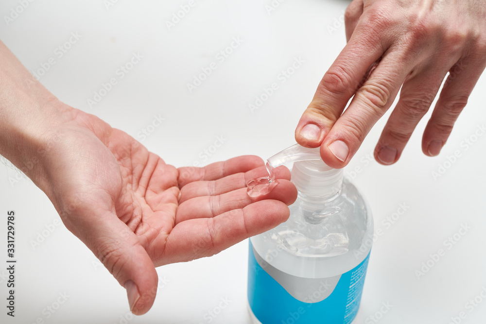 Close up of man's hands using antibacterial hand disinfection gel on white background Close up of man's hands using antibacterial hand disinfection gel on white background