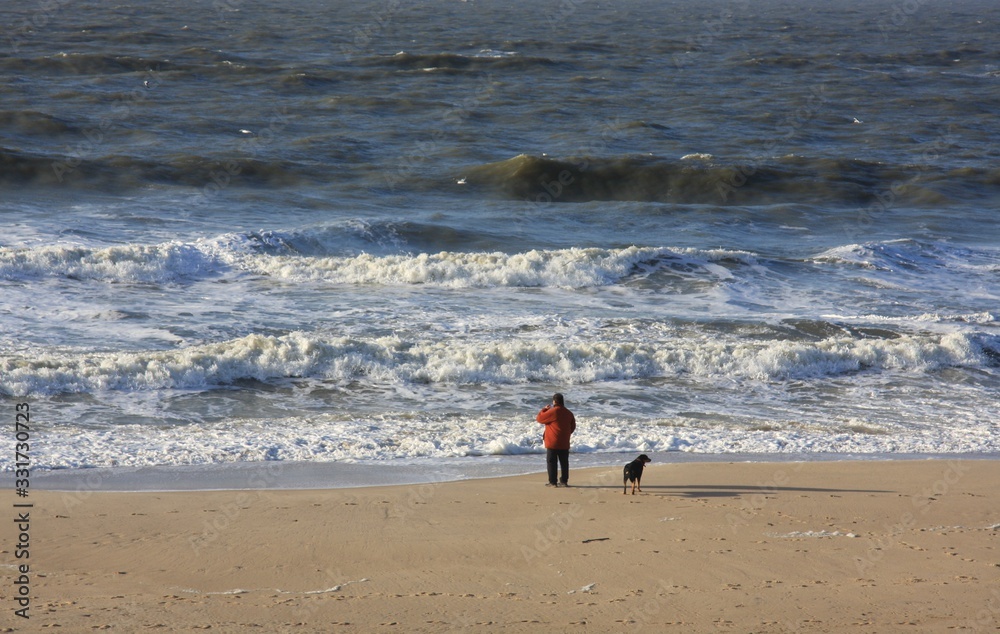 Lonely man with his dog looking at the sea