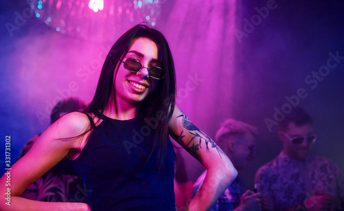 Young people is having fun in night club with colorful laser lights