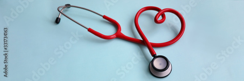 Red stethoscope with heart on blue modern background. Medical insurance concept photo