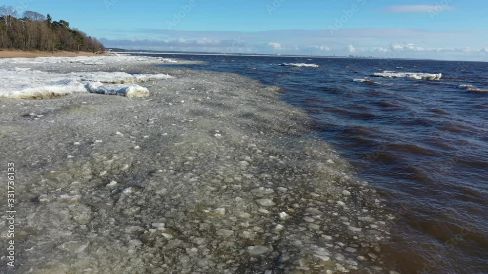 Spring flight over the coastline with pieces of ice floating on the waves Spring flight over the coastline with pieces of ice floating on the waves