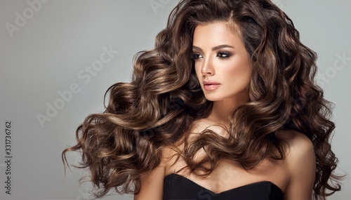 Fototapeta samoprzylepna Beautiful model girl with long wavy and shiny hair . Brunette woman with curly hairstyle