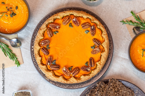 Pumpkin pie decorated with pecans on a served table for an autumn party food