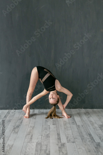 vertical studio portrait of a little gymnast on a slope