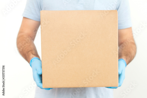 Delivery man holding cardboard boxes in medical rubber gloves / copy space. Fast and free Delivery transport . Online shopping and Express delivery . Quarantine 