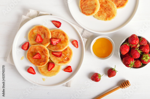 Cottage cheese pancakes with strawberry slices and honey