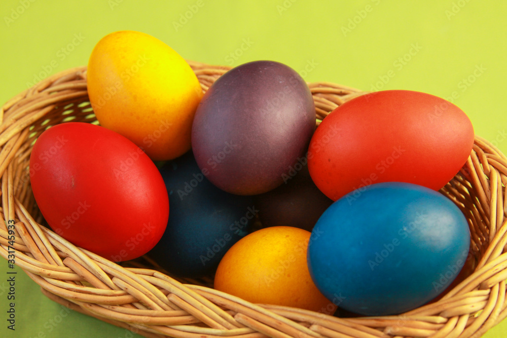 Easter eggs colors in basket green background Easter eggs colors in basket green background