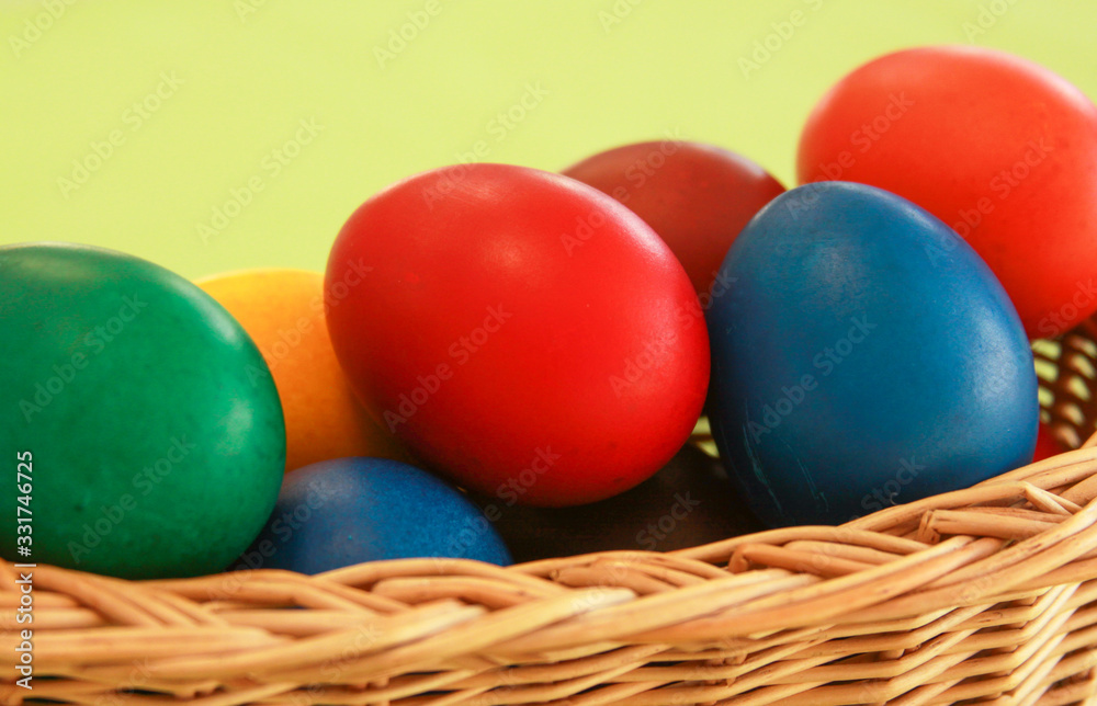 Easter eggs colors in basket green background Easter eggs colors in basket green background