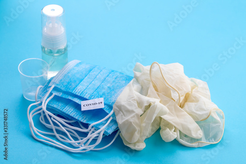 medical mask, gloves and disinfectant on blue background
