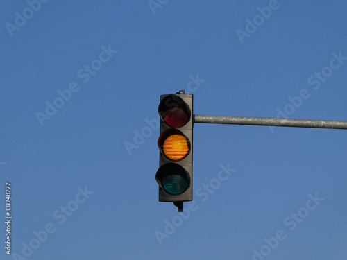 Yellow color on the traffic light with blue sky in background