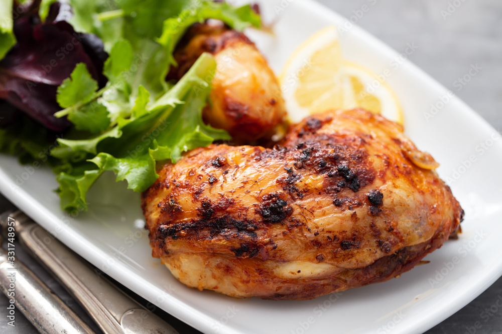grilled chicken with lemon and salad on white dish grilled chicken with lemon and salad on white dish