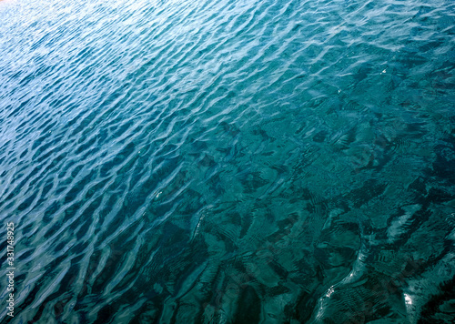 Bild auf Leinwand Ripples on water surface with reflections of sky and clouds
