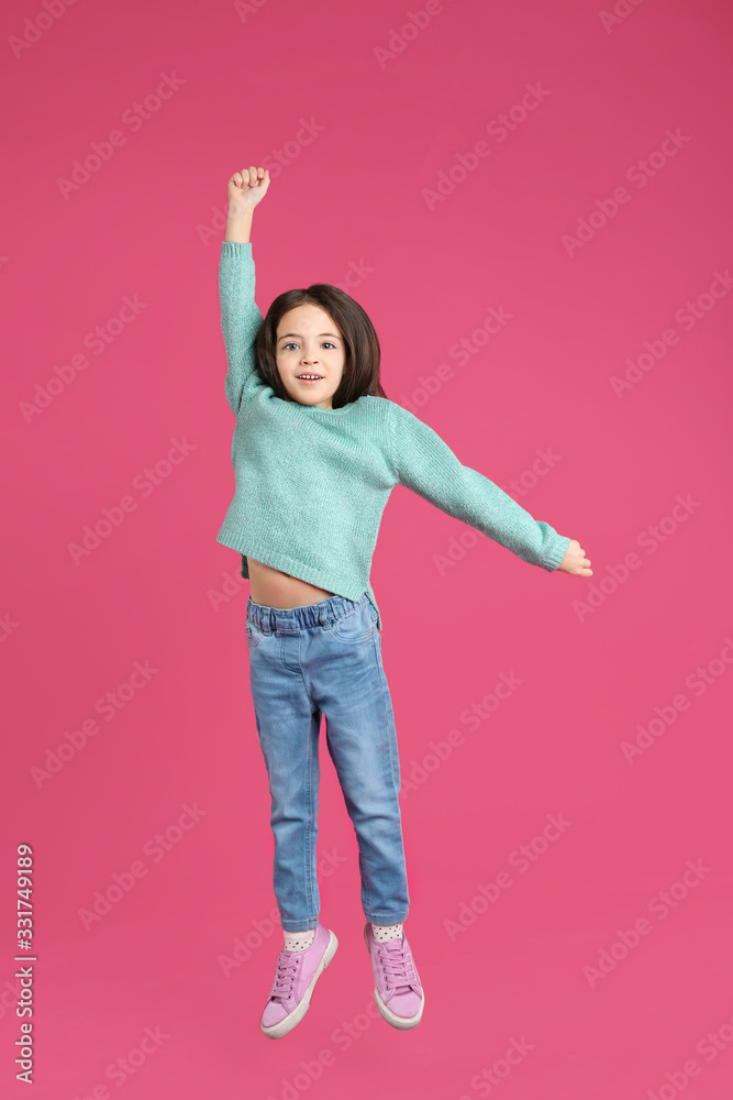 Cute little girl jumping on pink background Cute little girl jumping on pink background