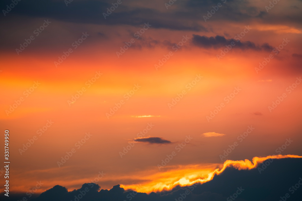 Beautiful colorful dark sunset sky with orange clouds. Nature sky background. 