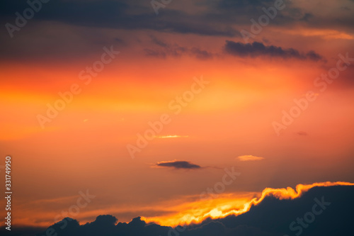 Beautiful colorful dark sunset sky with orange clouds. Nature sky background.  © Inga Av