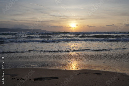 Golden dawn at sea, waves running onto the sand © Ruslan