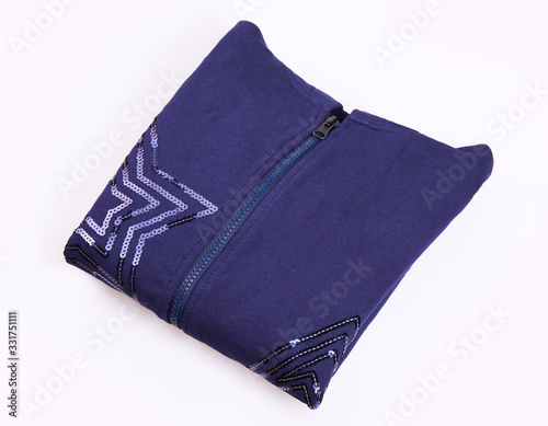 Blue folded zipped sweater decorated with sequins in star shape on white background. Clothes, fashion concept. Sportswear