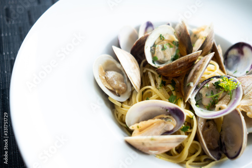 Clam pasta on a white plate - rich complex flavor - open clams