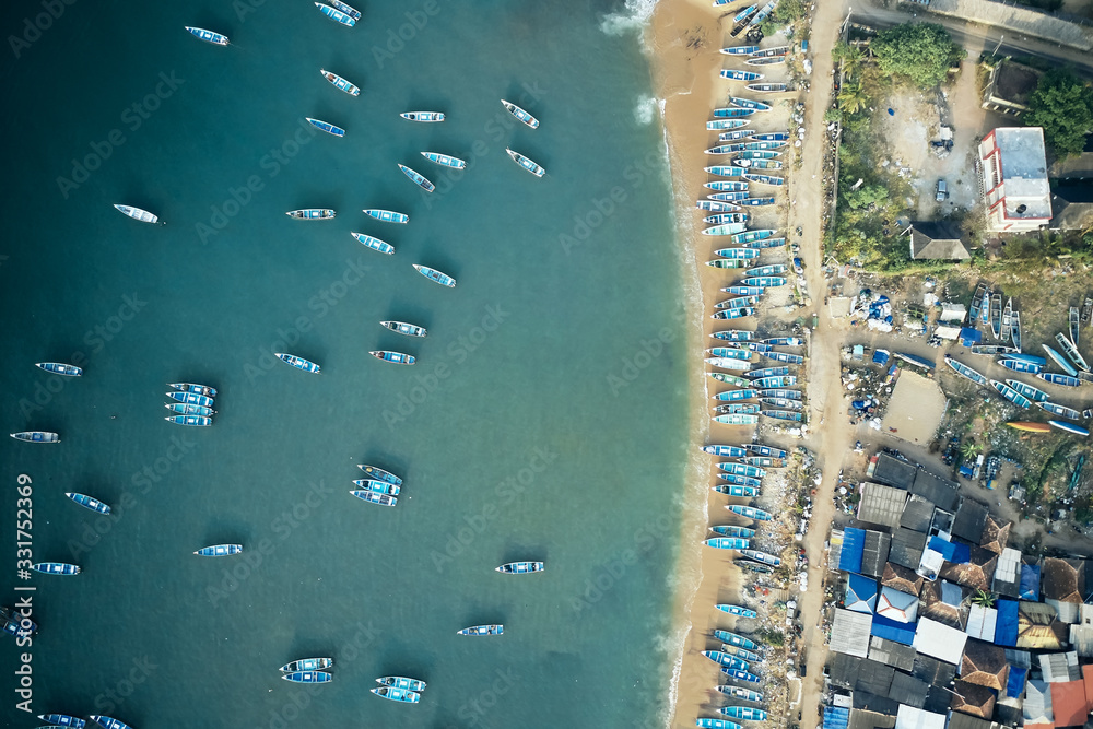 Aerial top view of fishing harbour with many traditional fisherman boats in Kerala, India.