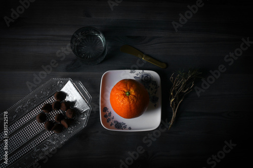 Imagen rustica de una mesa con una naranja y otros postres de chocolate