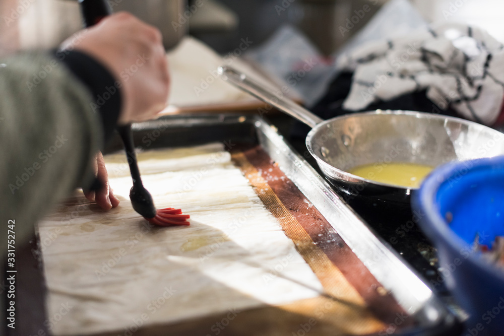 Hand preparing dough for baking with an egg wash Hand preparing dough for baking with an egg wash