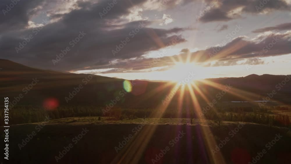 The sun 's rays break through the clouds in the mountains. Orange sunset. 4K. The sun 's rays break through the clouds in the mountains. Orange sunset. 4K.