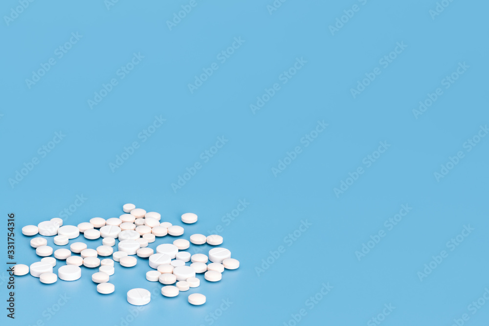 Tablets.    A lot of white pills are scattered on a medical blue background. Chinese Coronavirus, 2019-nCoV .