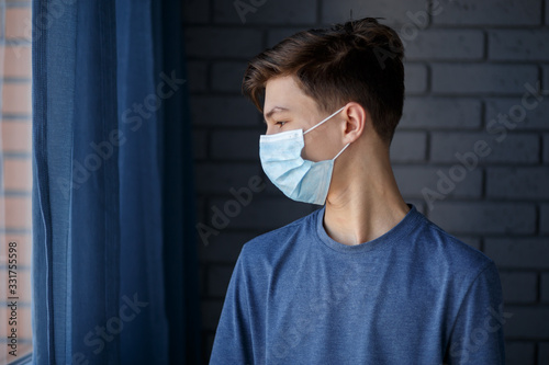  The guy is in quarantine. Coronavirus Covid 19. Child in observation. Dark background