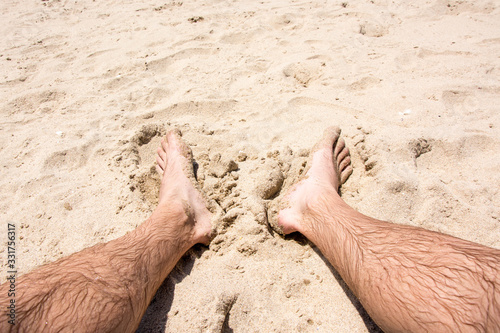 wet male feet in the sand at the beach
