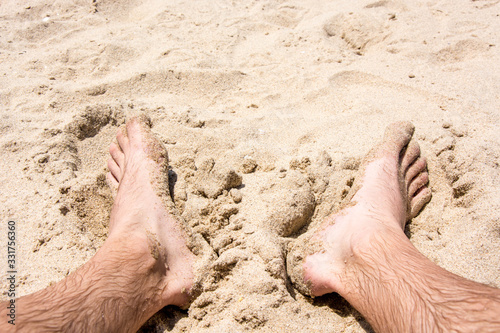 wet male feet in the sand at the beach