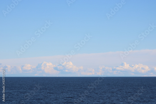 Clouds Hover Blue Ocean - Horizontal