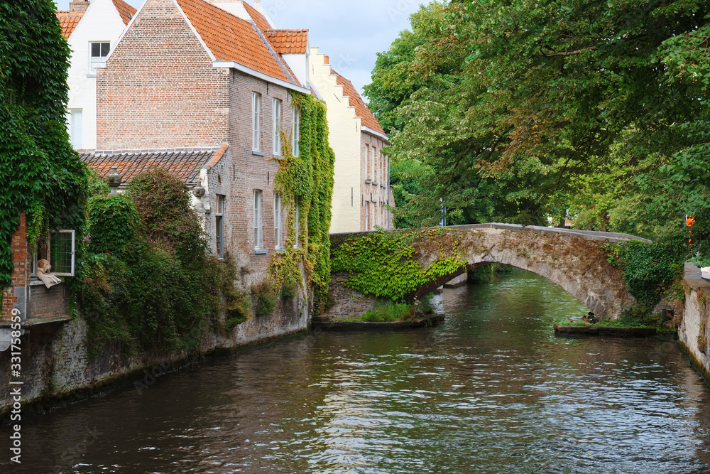 Bridge and medieval houses over a canal in Bruges, Belgium. Colorful old house in european city. Bruges (Brugge), Belgium, Europe.