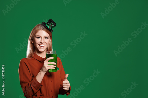 Young woman with green beer on color background, space for text. St. Patrick's Day celebration