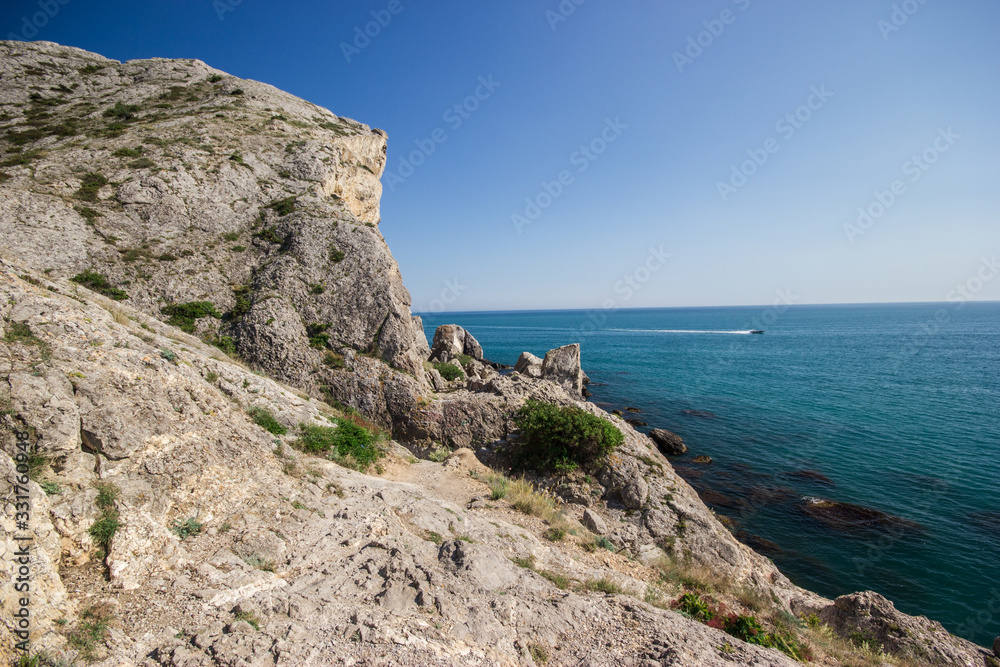 Seascape rocky terrain with boat on the waves