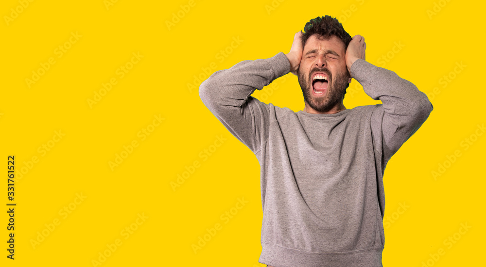 Young handsome man wearing casual sweater standing over isolated yellow background angry and mad screaming frustrated and furious, shouting with anger. Rage and aggressive concept. Young handsome man wearing casual sweater standing over isolated yellow background angry and mad screaming frustrated and furious, shouting with anger. Rage and aggressive concept.