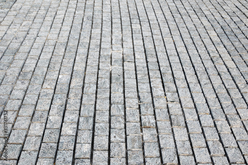 Texture of gray paved pavement, abstract background of gray, granite cobblestones.