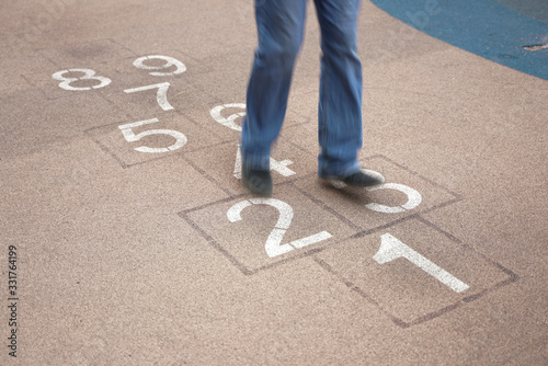 teenager playing hopscotch on playground outdoors, children outdoor activities