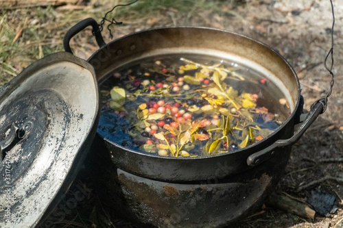 A pot with a herbal tea on the ground