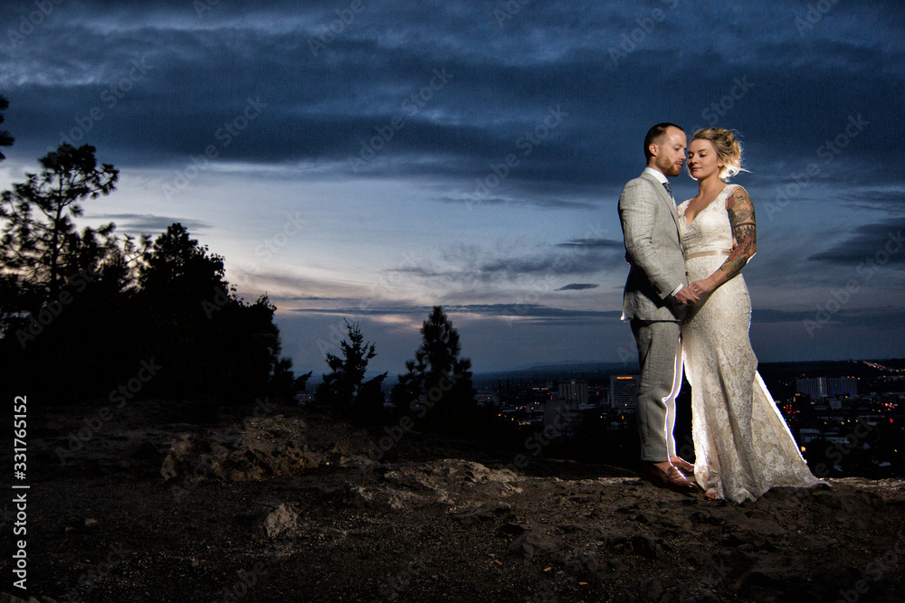 Bride and groom posing in front of sunset Bride and groom posing in front of sunset