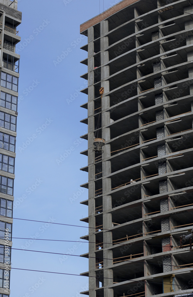 Fototapeta premium High-rise building under construction. Reinforced concrete frame. Start of installation of double-glazed windows.