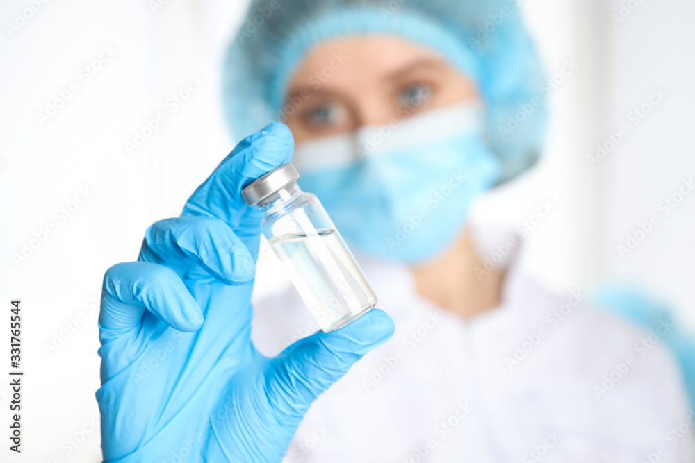 Doctor holding vial with medication, closeup. Vaccination and immunization Doctor holding vial with medication, closeup. Vaccination and immunization
