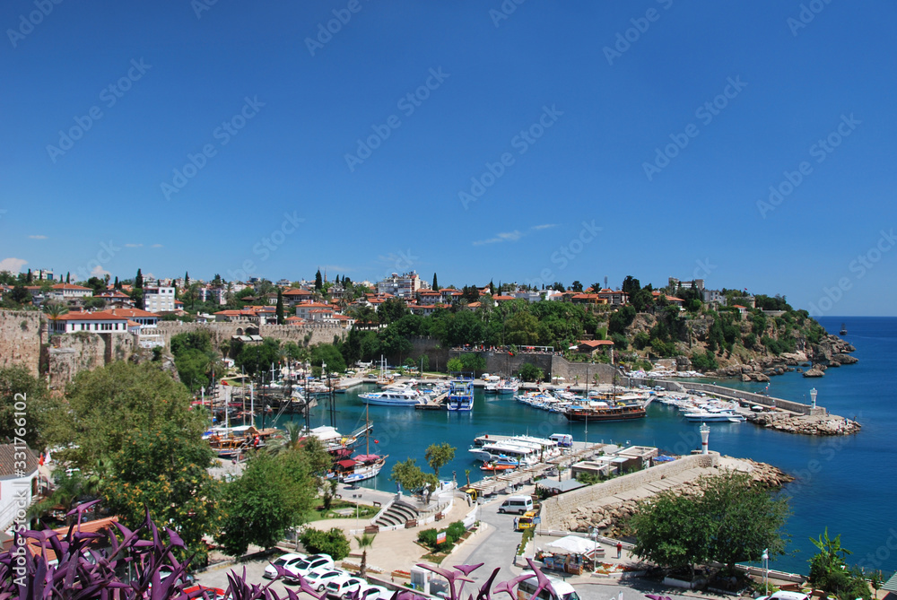 Top view of the sea port in Antalya. Ancient Turkish port on the Mediterranean coast. Ships in the port of the fortress city.