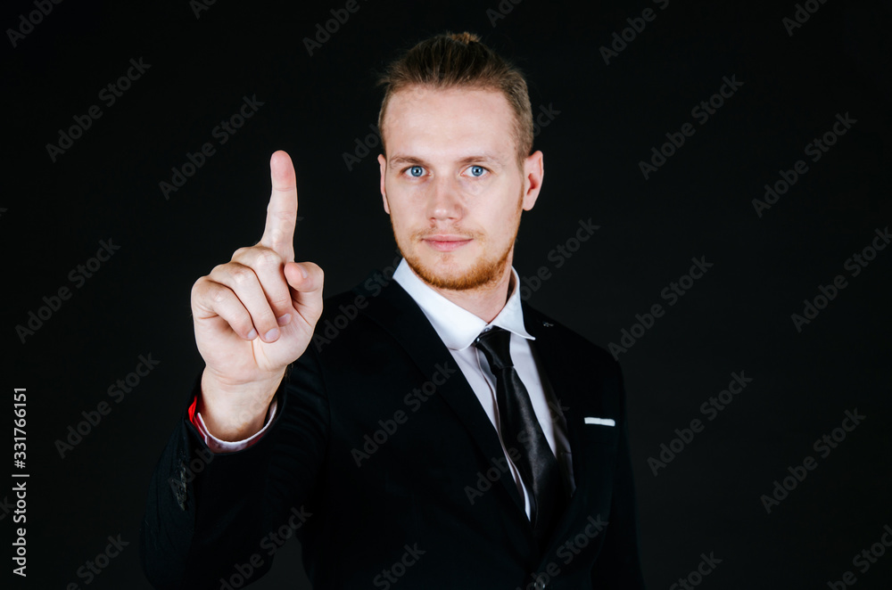 smart caucasian business man in modern black suit hand touching virtual screen or pressing button on dark background with copy space for advertisement, business people and digital technology concept