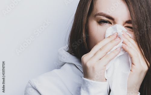 woman sneezes into a napkin